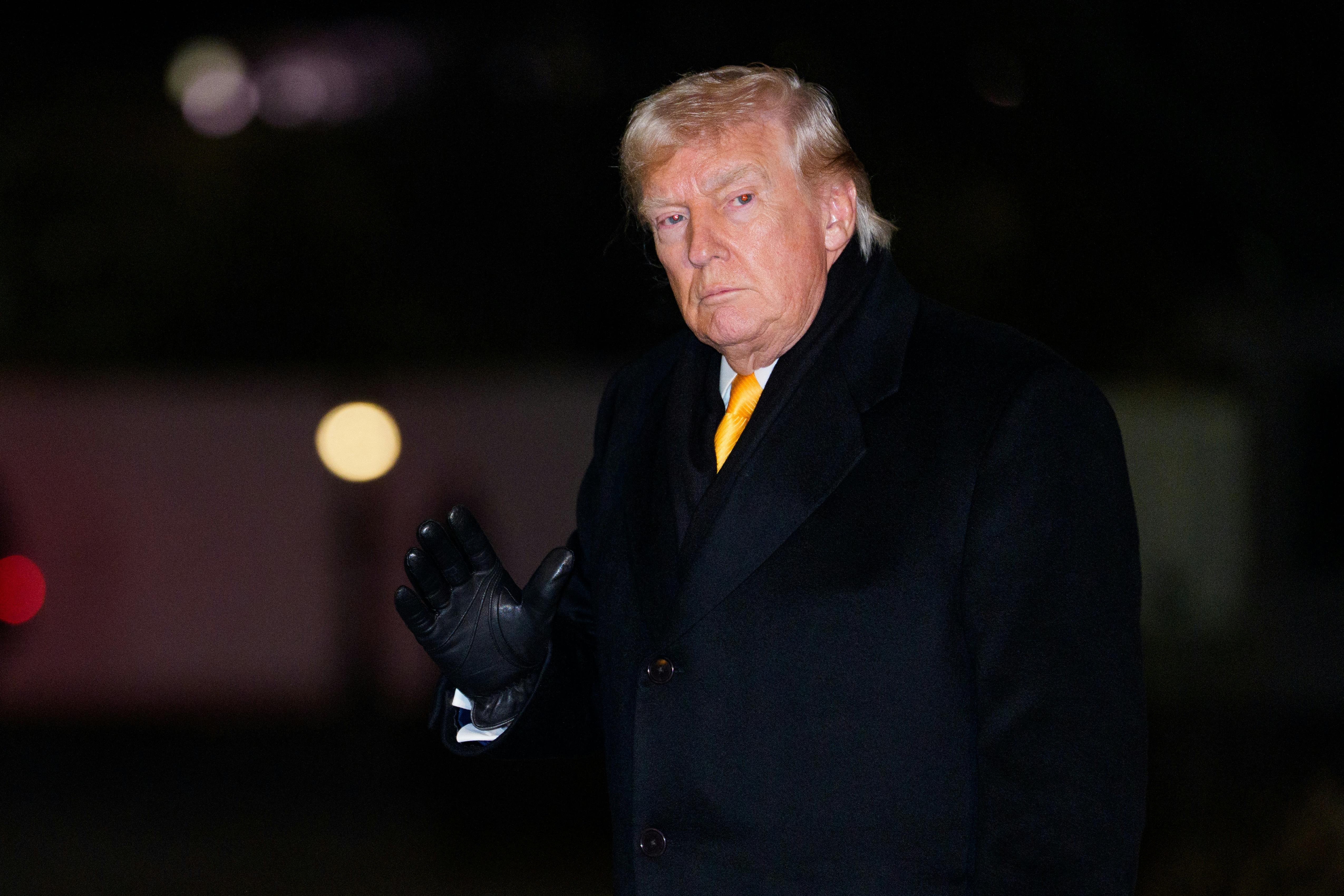 Donald Trump waves while walking outside the White House