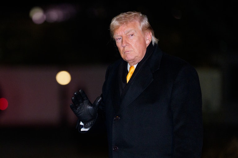 Donald Trump waves while walking outside the White House