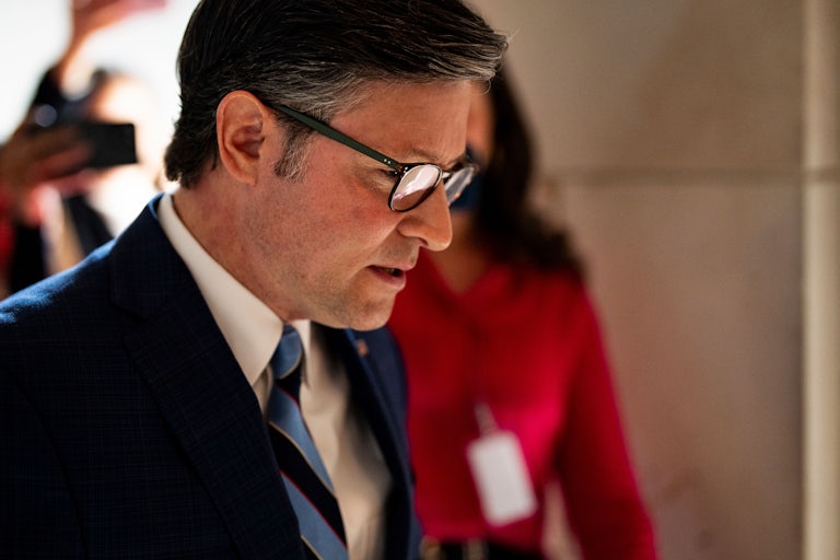 House Speaker Mike Johnson looks down while walking in the Capitol