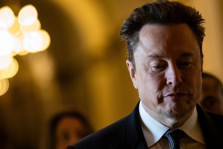 Elon Musk looks downward while walking in Congress