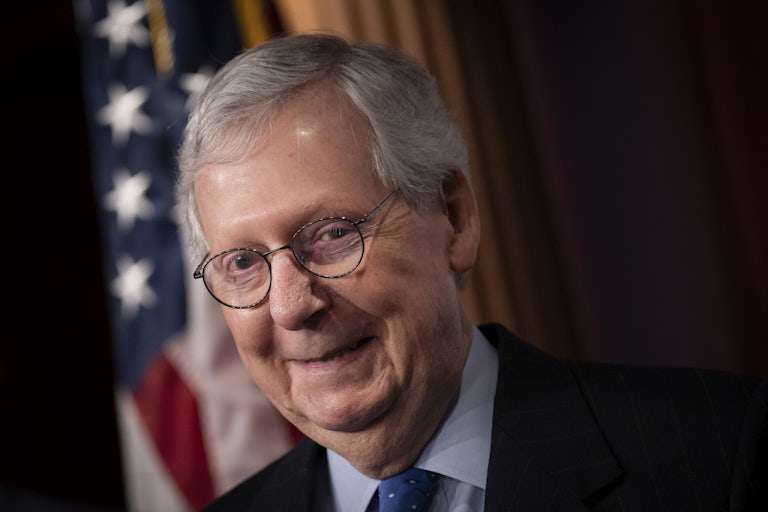 Mitch McConnell does a creepy toothless grin as he looks down
