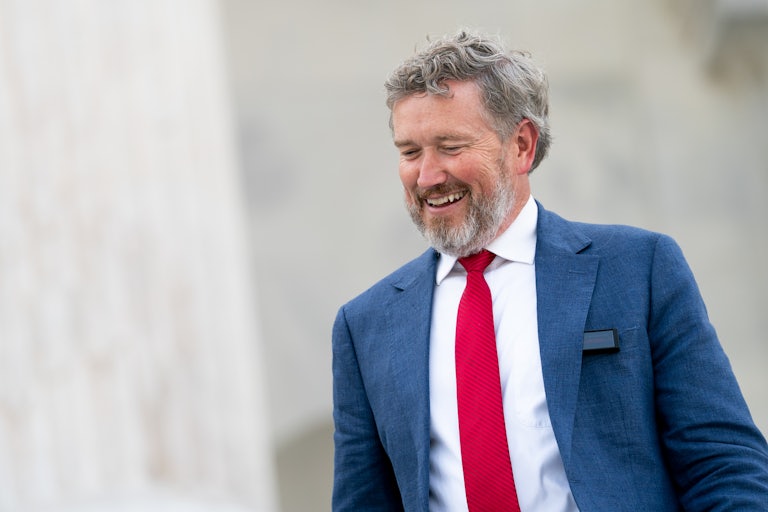 Representative Thomas Massie smiles while walking outside the Capitol