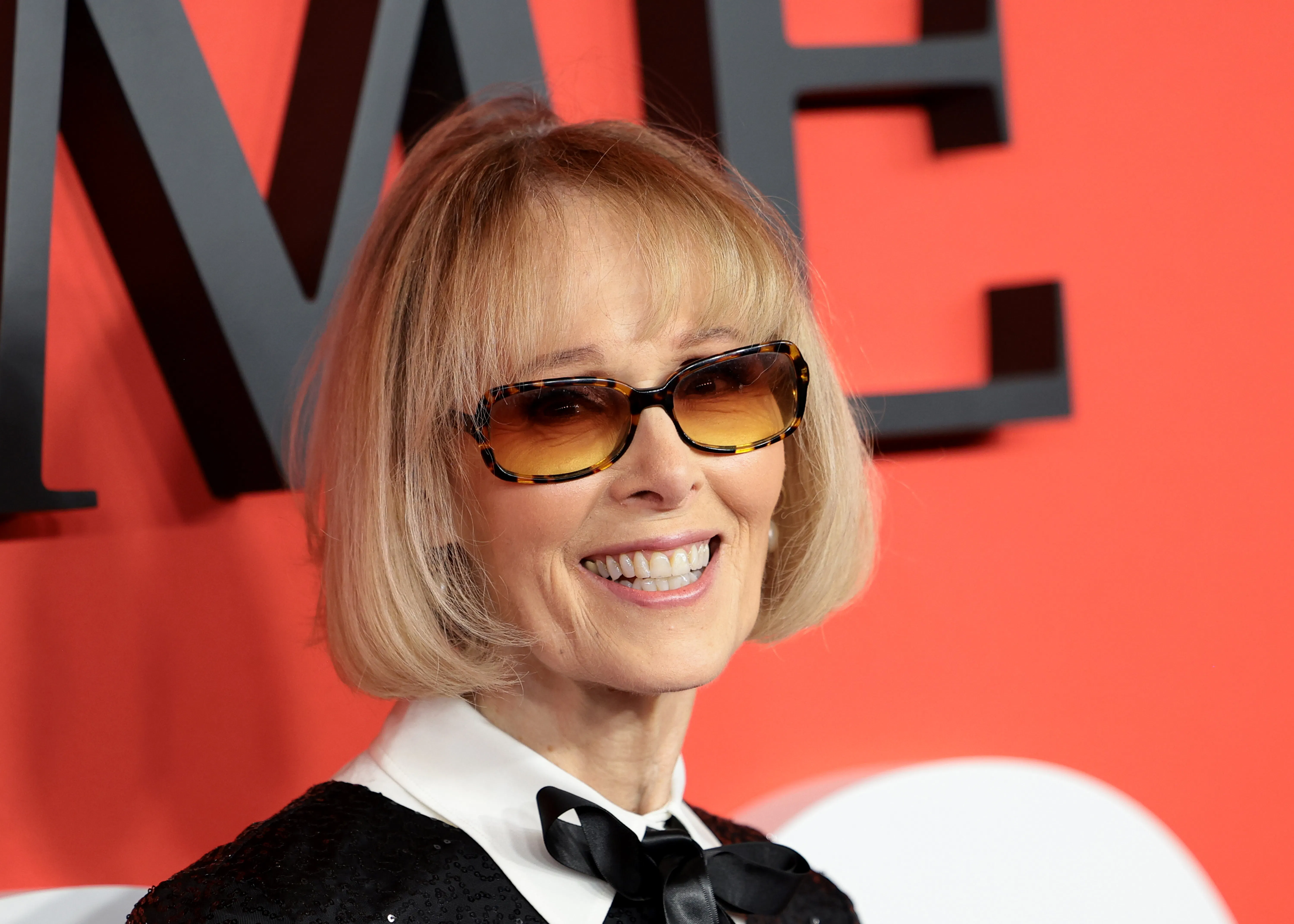 E. Jean Carroll smiles in front of a TIME backdrop.