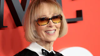 E. Jean Carroll smiles in front of a TIME backdrop.