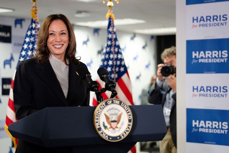 Kamal Harris smiles while standing at the podium during her first presidential event