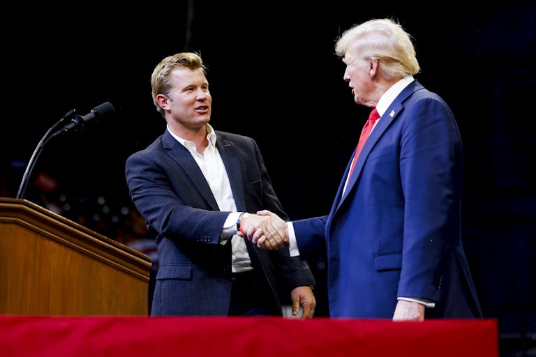 Tim Sheehy shakes hands with Donald Trump on a campaign stage