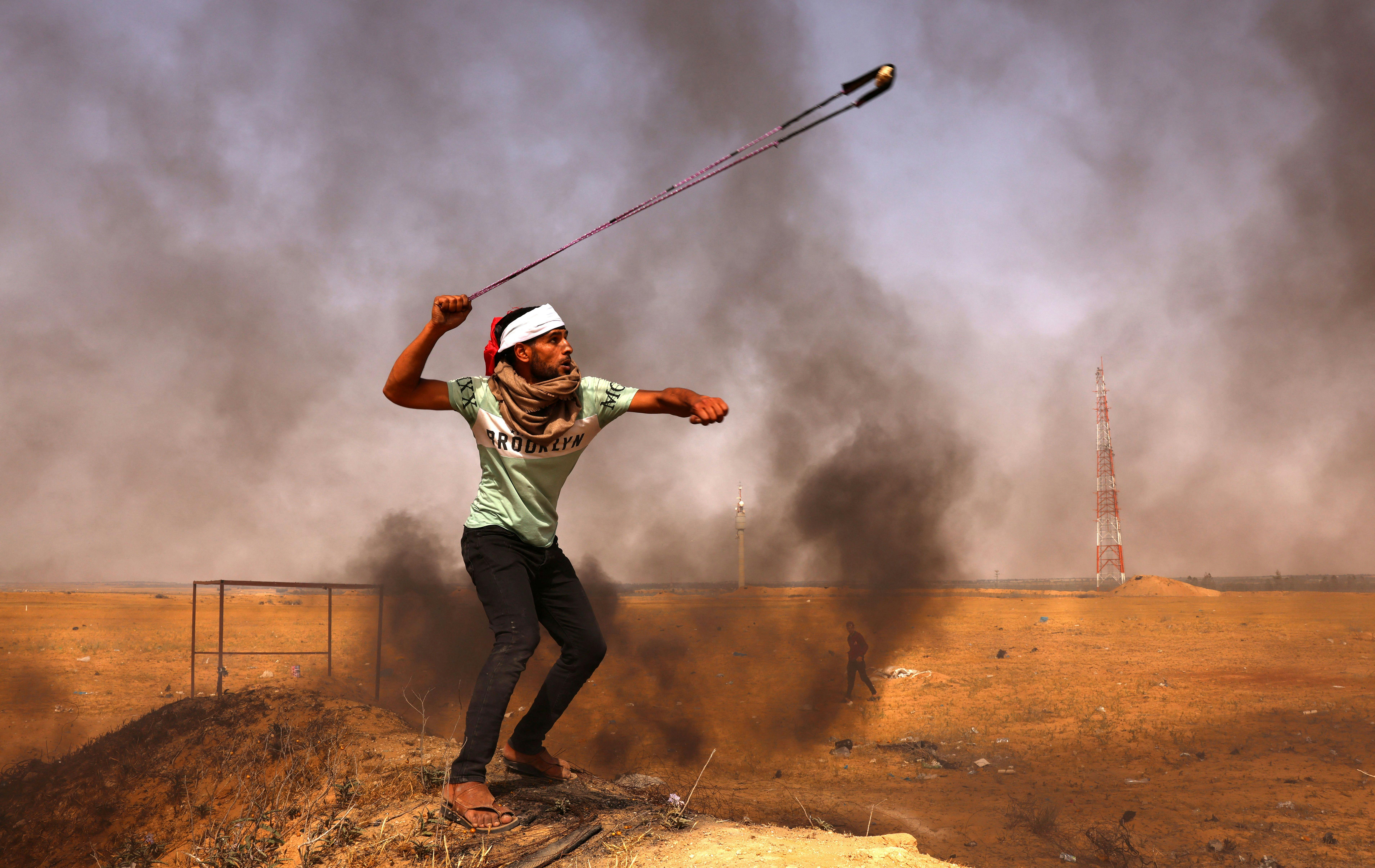 A Palestinian demonstrator hurls a rock during a protest in the Gaza Strip.