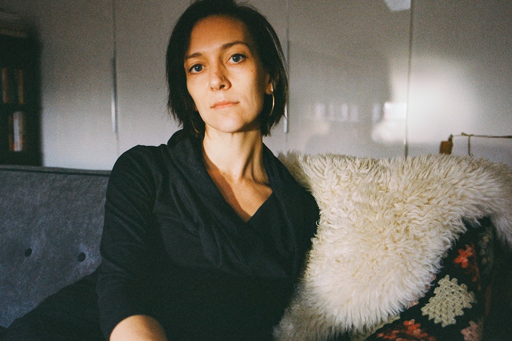 Author Catherine Lacey leans against a couch in New York in March 2023.