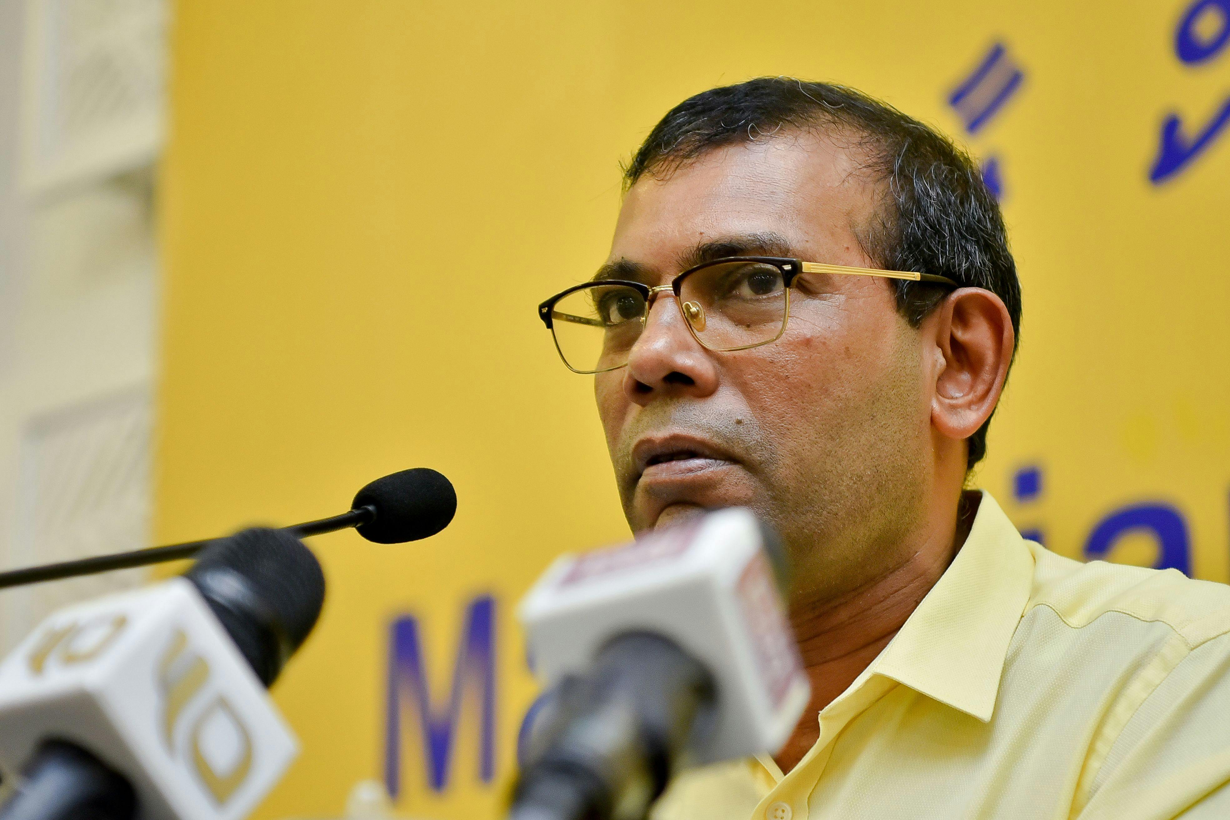 Mohamad Nasheed speaks in front of several microphones.