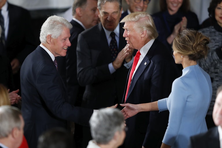 Bill Clinton shakes hands with Donald Trump as Melania looks on.