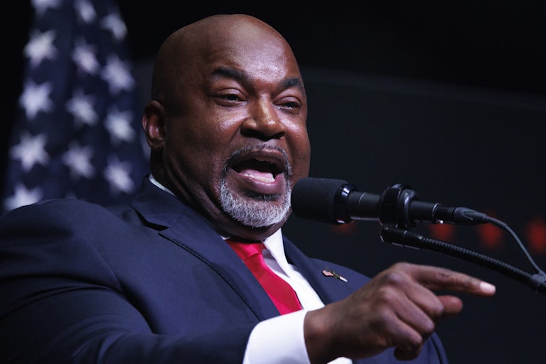 Mark Robinson points and speaks into a microphone