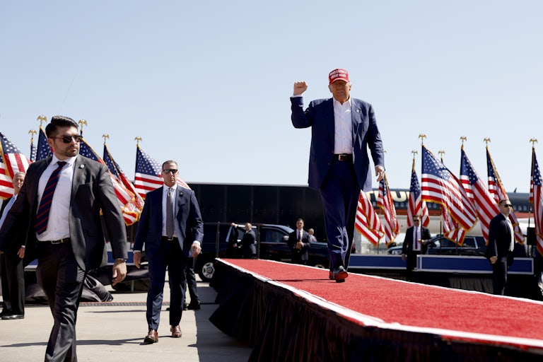 Donald Trump pumps his fist as he walks at a campaign rally