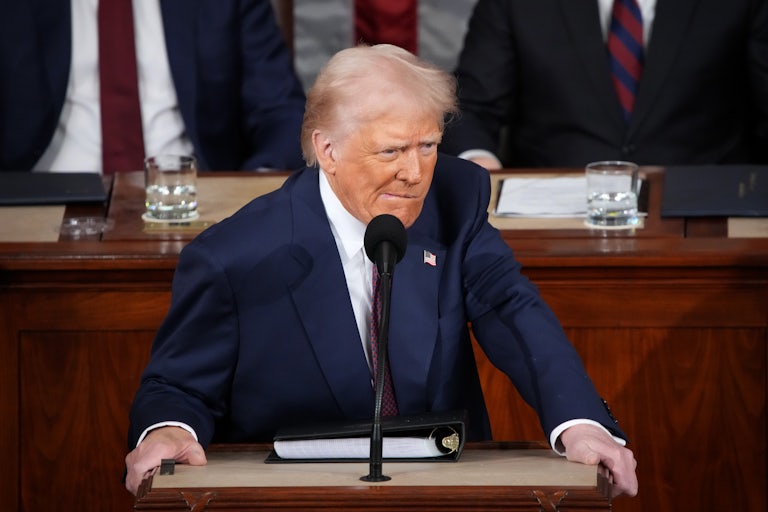 Donald Trump bites his lip while standing at the podium during his address to a joint session of Congress