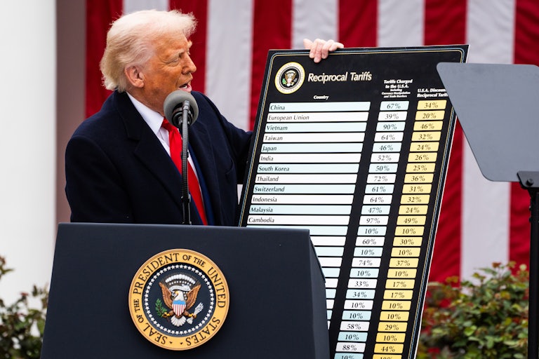 Donald Trump holds up a chart showing tariff rates for different countries during a White House Rose Garden press conference