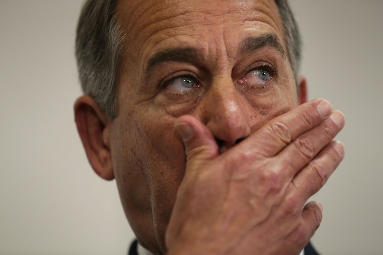 John Boehner covers his mouth while listening to a news briefing.