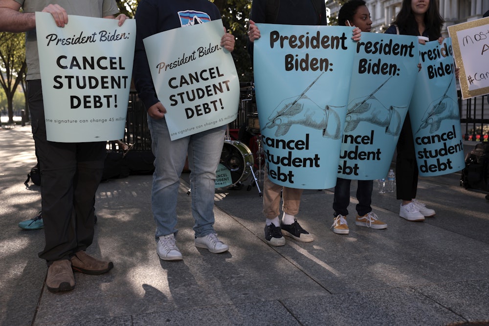 Activists hold signs as they attend a Student Loan Forgiveness rally near the White House.