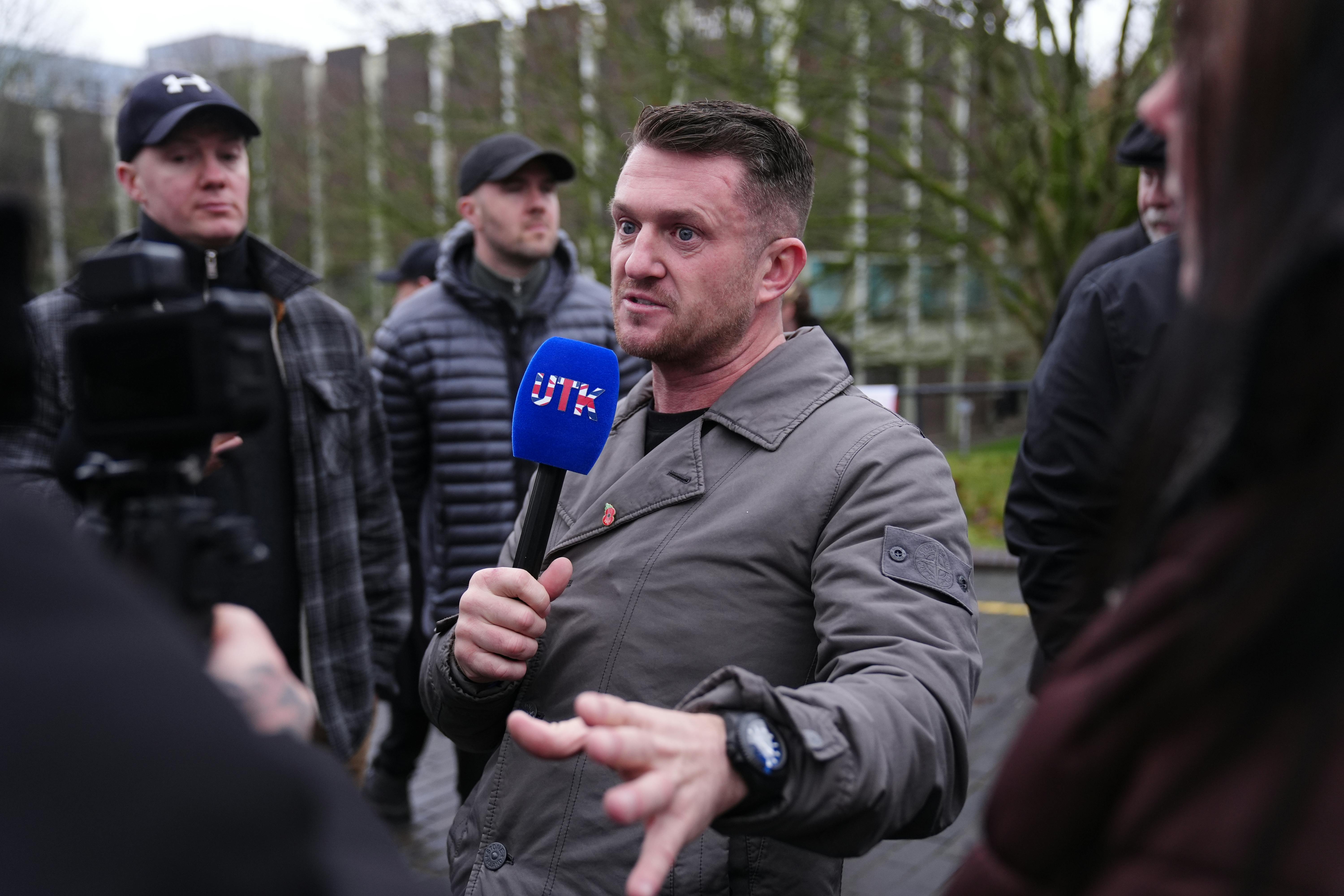 U.K. far-right activist Tommy Robinson speaks with a microphone in his hand