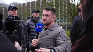 U.K. far-right activist Tommy Robinson speaks with a microphone in his hand