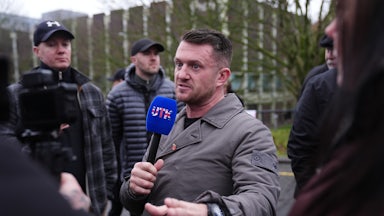 U.K. far-right activist Tommy Robinson speaks with a microphone in his hand