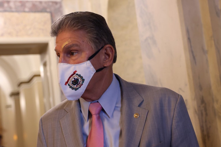 Joe Manchin looks to his right, wearing a face mask.