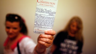 Elementary school teacher Lisa Petry of Virginia Beach, Virginia, holds up a copy of the U.S. Constitution while waiting in line to attend a House Judiciary Committee hearing.