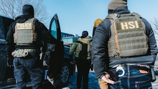 Federal immigration agents stand in a parking lot in Minneapolis, Minnesota