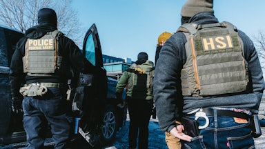 Federal immigration agents stand in a parking lot in Minneapolis, Minnesota