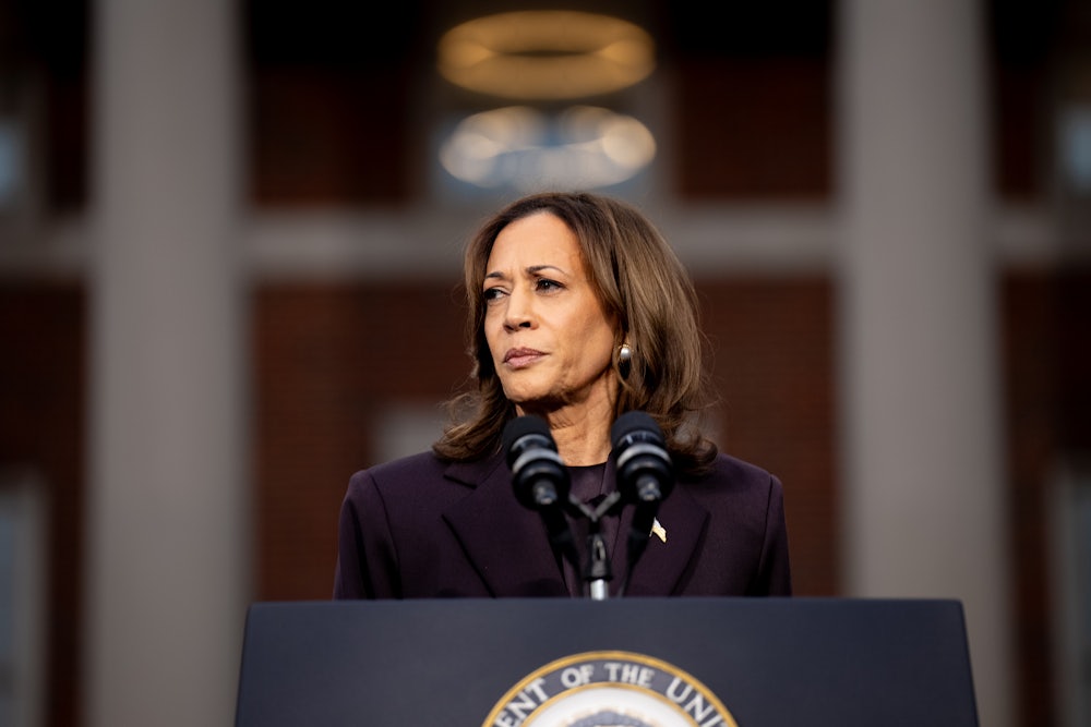 Kamala Harris looks leftward off camera while standing at a podium.