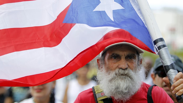 A man carries a Puerto Rican flag during a protest in San Juan