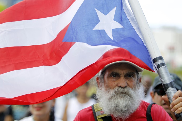 A man carries a Puerto Rican flag during a protest in San Juan