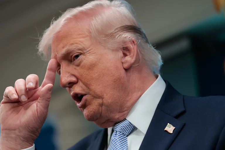 President Trump places his index finger on his forehead