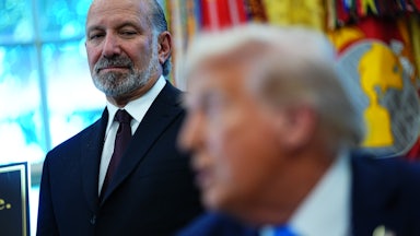 Commerce Secretary Howard Lutnick looks on as Donald Trump speaks.