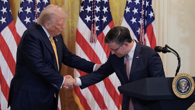 President Donald Trump and House Speaker Mike Johnson shake hands.