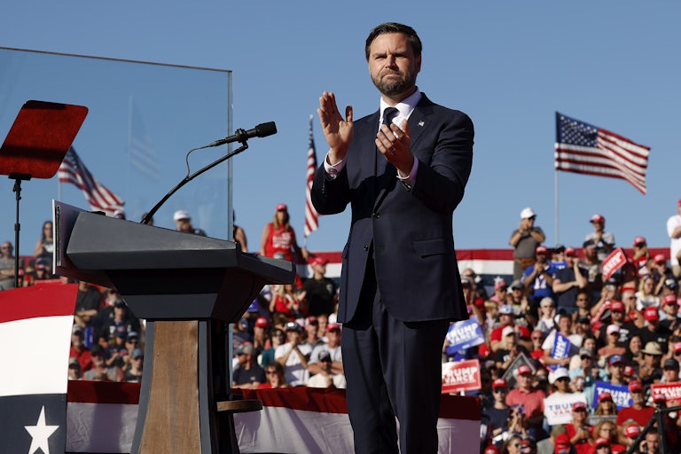 JD Vance claps while on stage at a Donald Trump rally