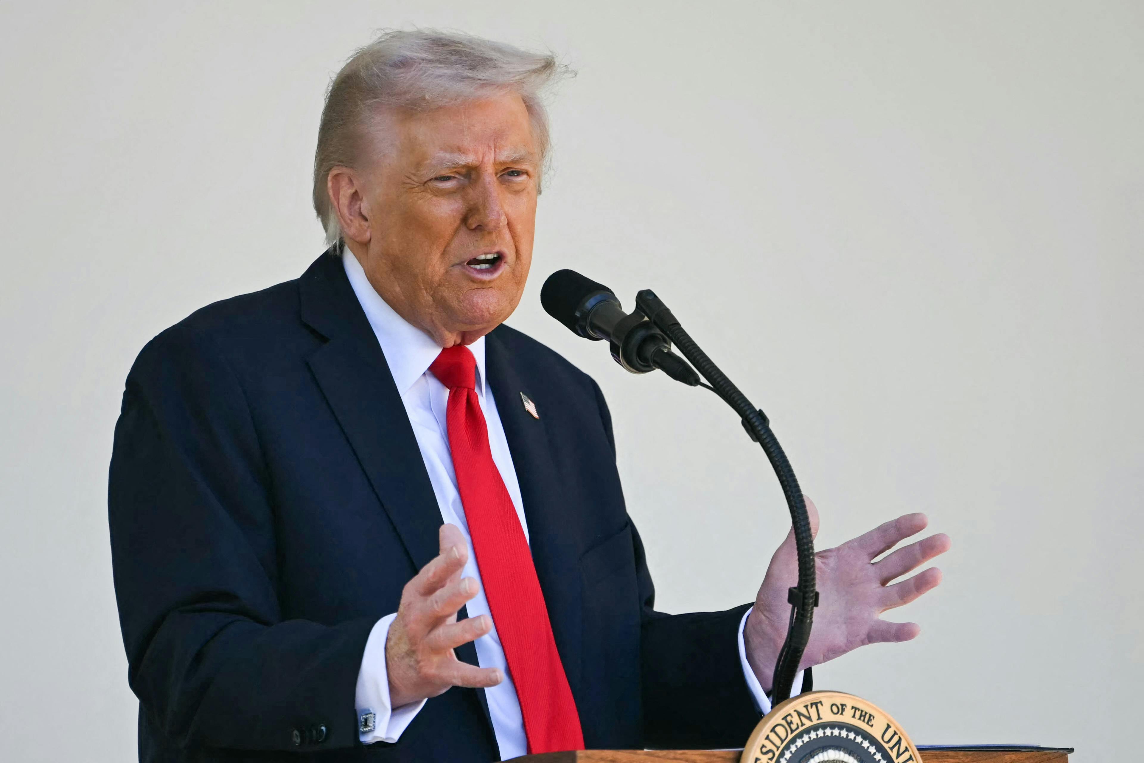 Donald Trump gestures while speaking at a podium