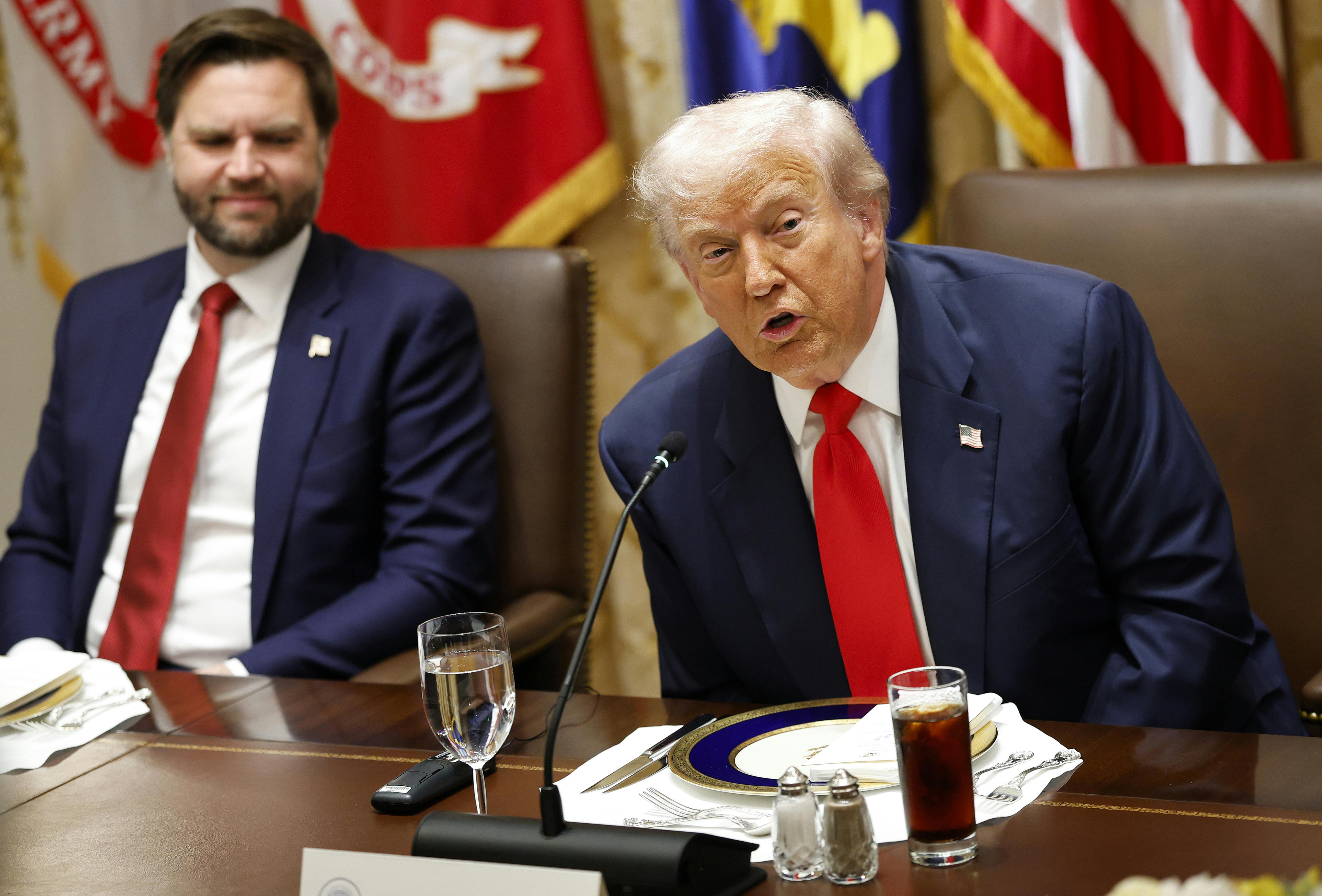 JD Vance and Donald Trump sit at a table in a meeting with Argentine President Javier Milei (not pictured)