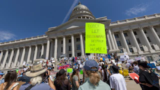 Protesters hold signs in front the of the Utah State Capitol building to oppose the construction of the Stratos data center in Box Elder County, Utah.