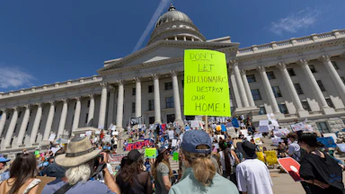 Protesters hold signs in front the of the Utah State Capitol building to oppose the construction of the Stratos data center in Box Elder County, Utah.