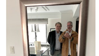 Jeffrey Epstein smiles and holds up a phone to take a photo of him and Steve Bannon as they look into a mirror.