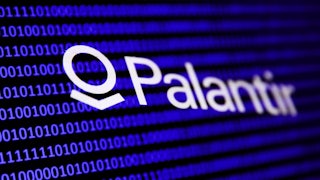 Palantir logo over some code on a screen