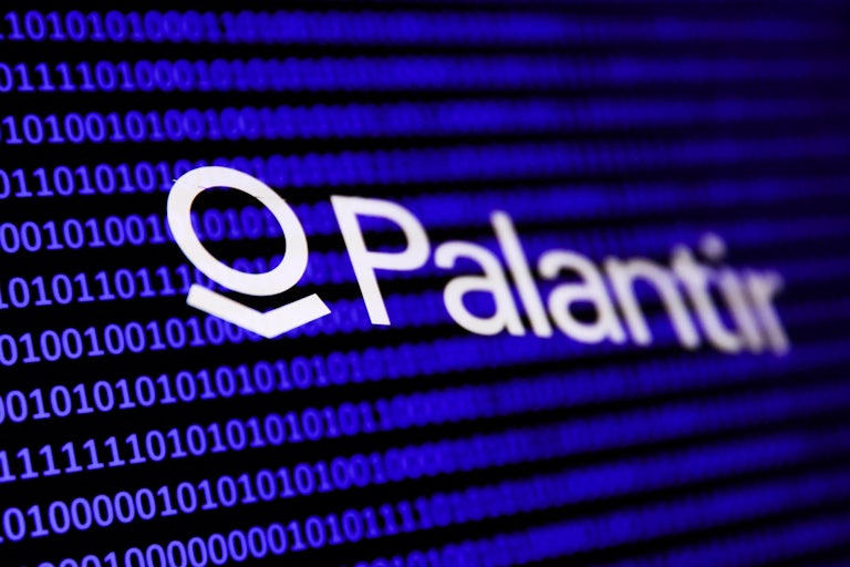 Palantir logo over some code on a screen