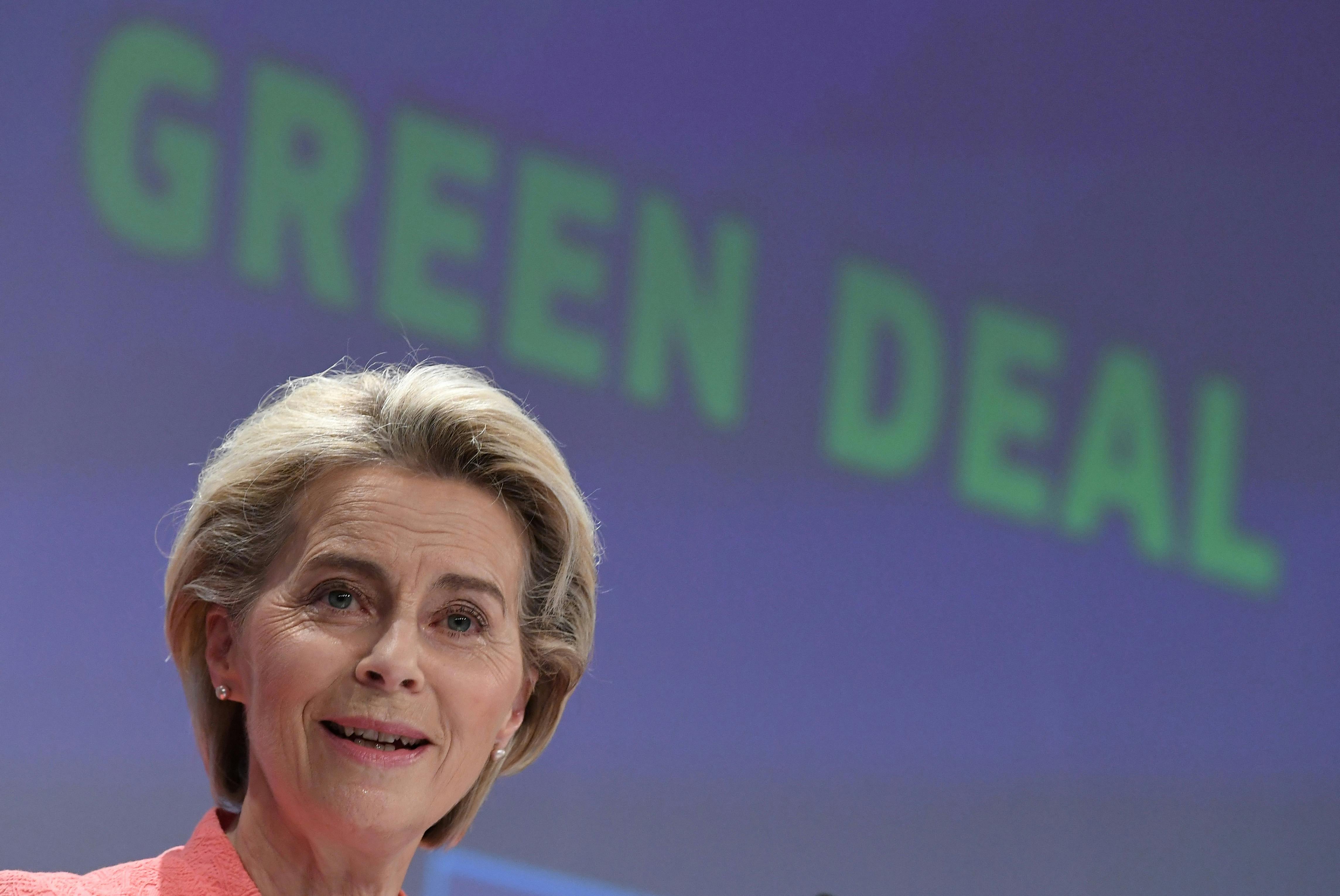 Ursula von der Leyen speaks in front of a screen reading "Green Deal."