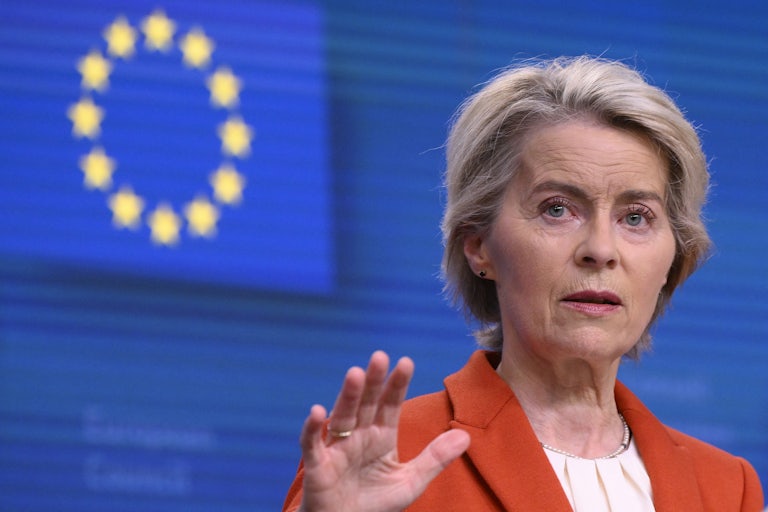 European Commission President Ursula von der Leyen delivers a speech with an EU flag in the background.