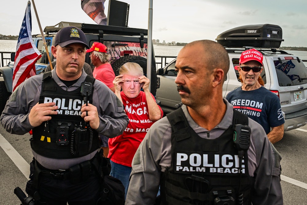On July 17, police officers stood near Trump supporters gathered near Mar-a-Lago during a national day of action against the Trump administration.