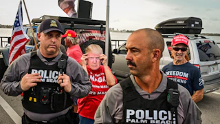 On July 17, police officers stood near Trump supporters gathered near Mar-a-Lago during a national day of action against the Trump administration.