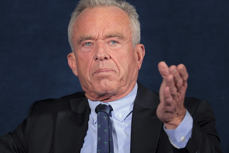 Robert F. Kennedy Jr. gestures while sitting on stage during an event
