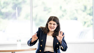Haley Stevens speaks and pushes her arms out