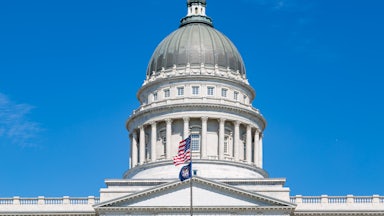 Utah state Capitol with a U.S. and Utah flag flying in front