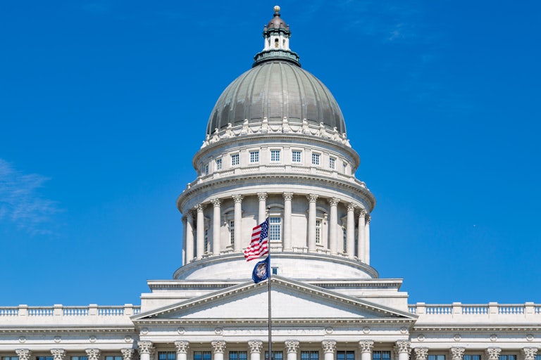 Utah state Capitol with a U.S. and Utah flag flying in front