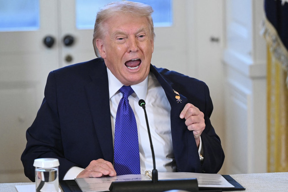 Donald Trump, sitting, speaks vehemently with wide-open mouth